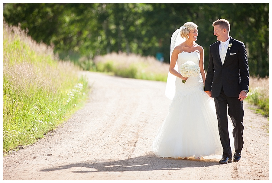 25 Bride and Groom walking on dirt road in Beaver Creek Colorado