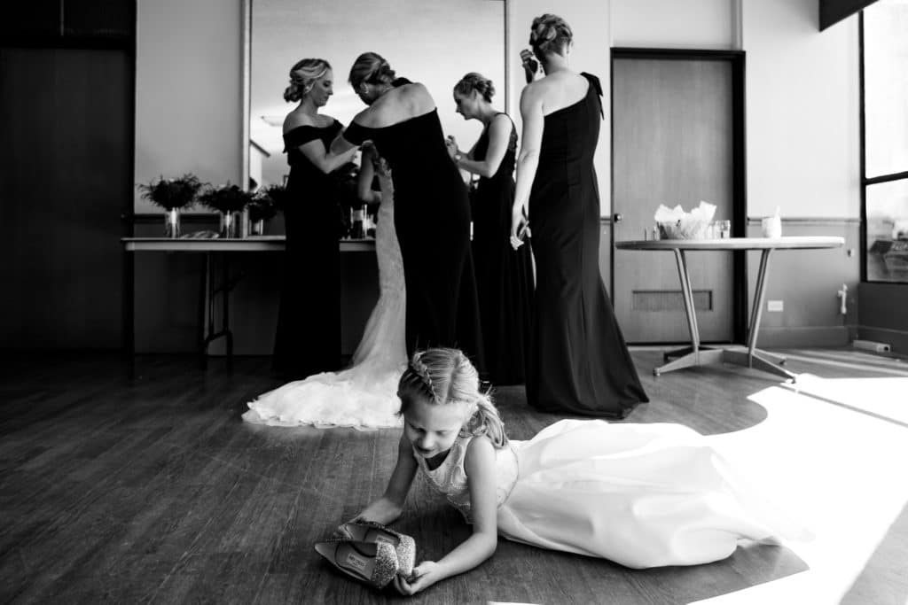 Flower girl playing with bride's shoes