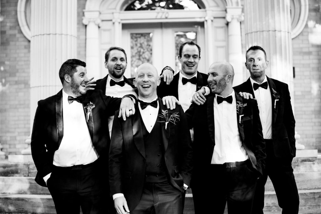 Groom laughing with groomsmen at Grant Humphreys mansion