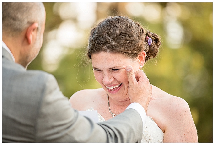Groom wiping tear from Bride's face
