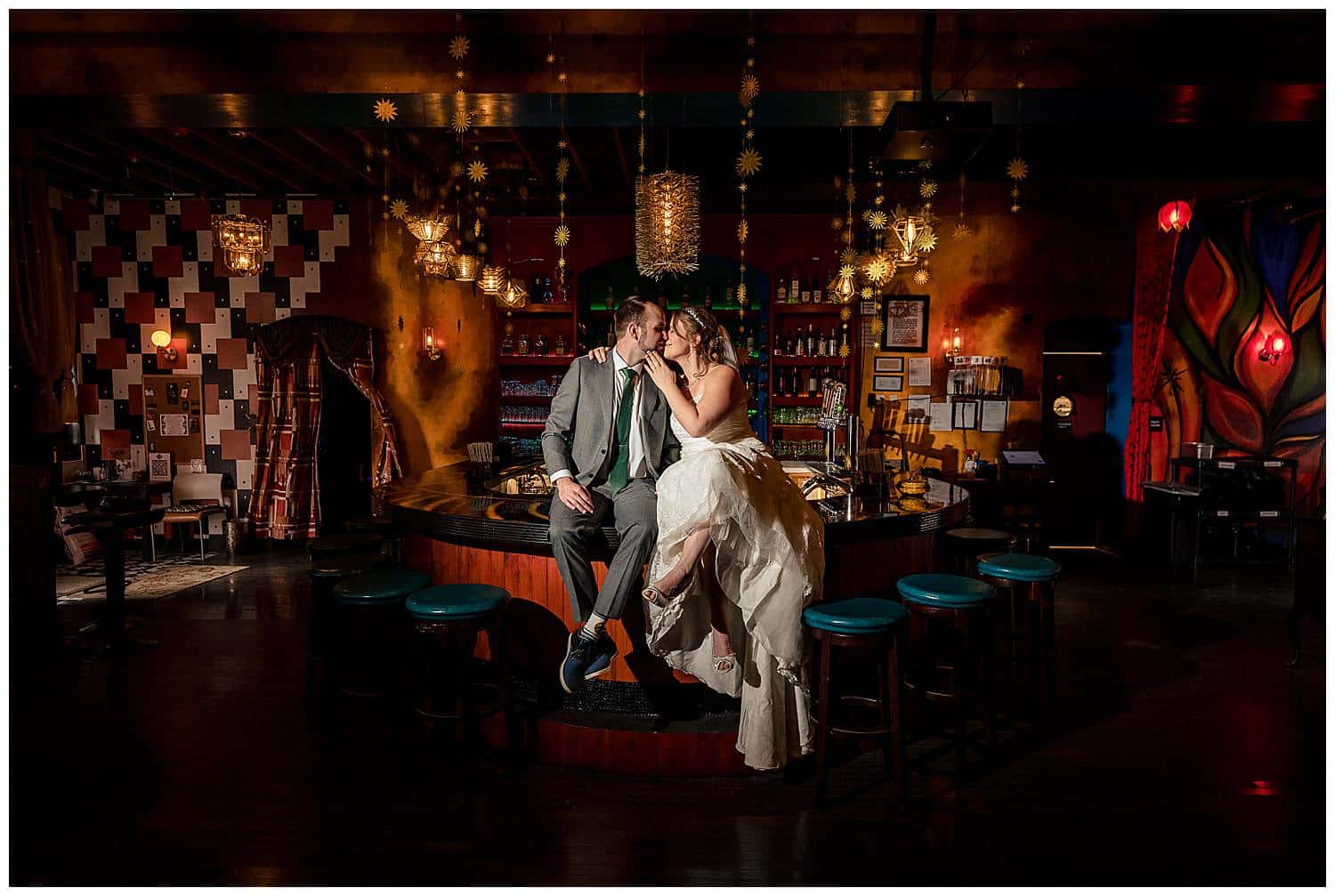 Bride and Groom kissing at bar inside Enigma Bazaar

